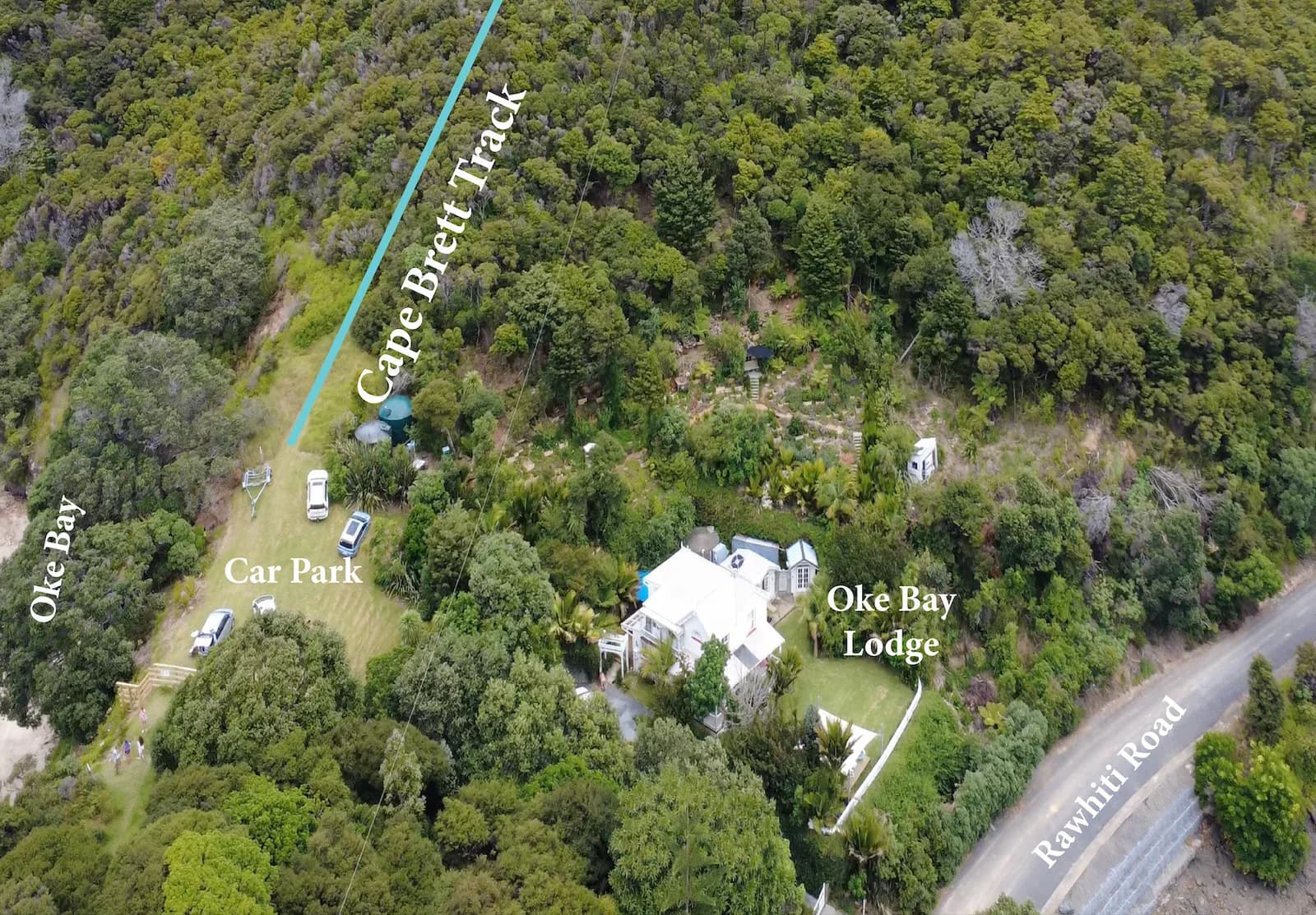 Aerial view of Oke Bay Lodge, the carpark, and the start of the Cape Brett Track.